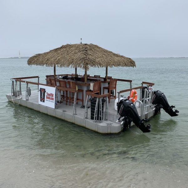 Tom’s Tiki Boat anchored with guests enjoying the shallow water