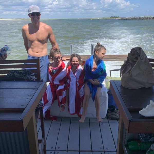 IMG_2786 (Medium) Father and kids relaxing on a Tom’s Tiki Boat Tour deck with beach towels
