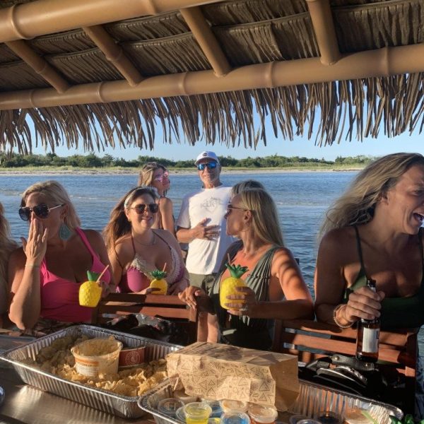 Group of women gathered around food and drinks on a Tom’s Tiki Boat