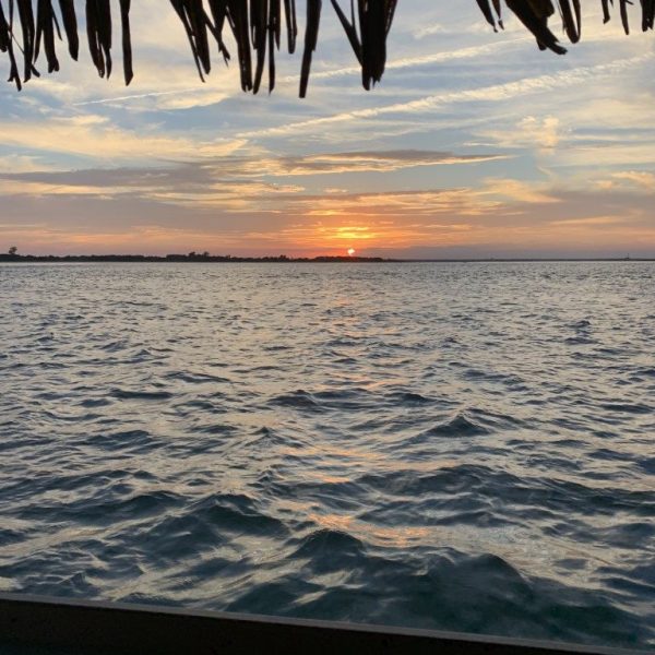 Open water sunset view from the back of a tiki boat in Beach Haven